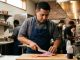 Houston chef preparing Japanese-inspired seafood dishes in a modern Texas restaurant kitchen