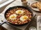 Crispy golden home fries with over easy eggs in a skillet